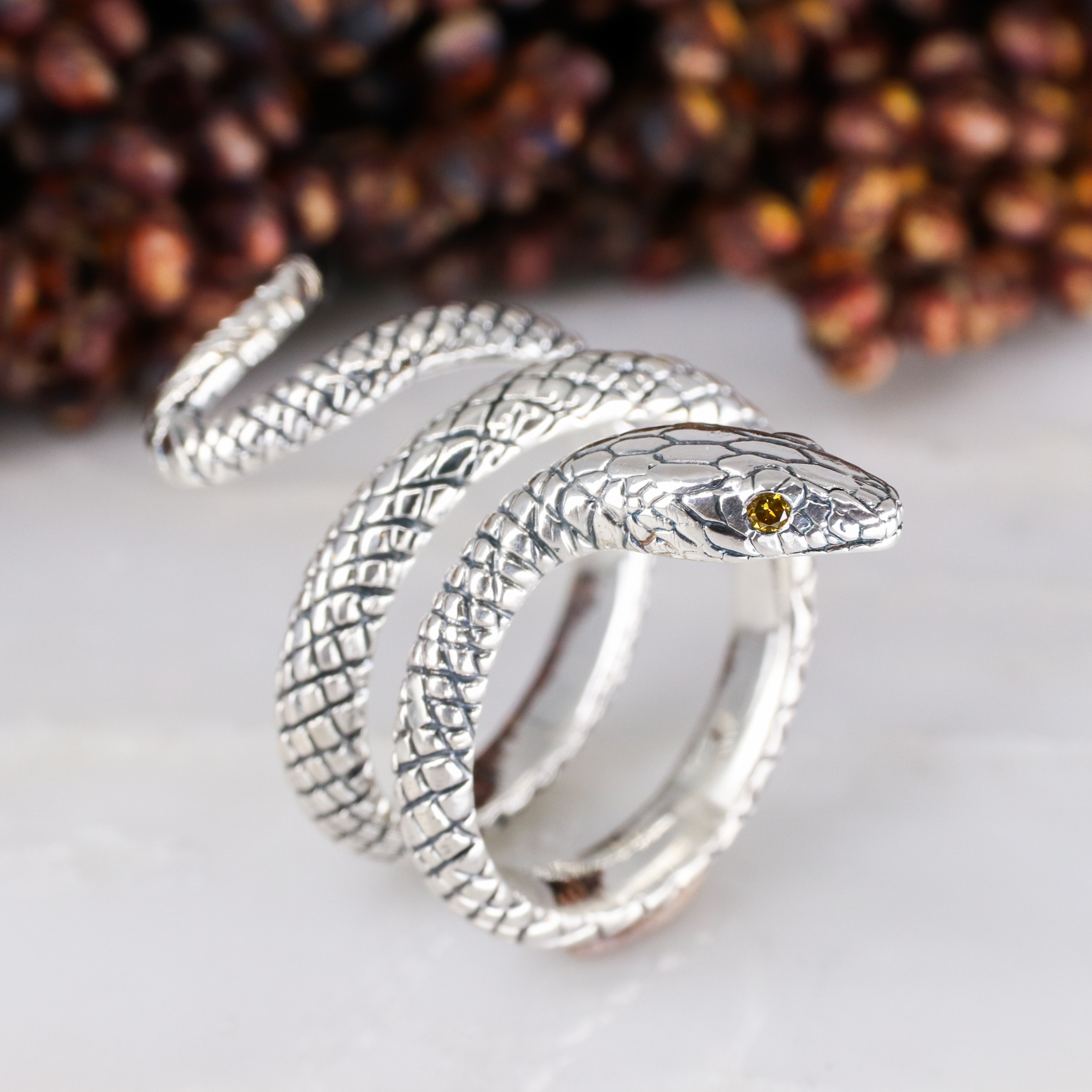 Silver coiled snake ring with orange diamond eyes - Baroque Jewellery